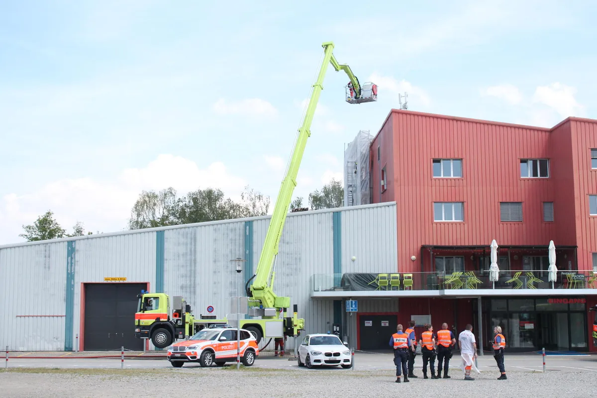 img_0915 Mit einer Feuerwehr-Hebebühne versuchen die Einsatzkräfte, die Rauchentwicklung unter Kontrolle zu bringen., Ein Feuer hat man laut Kantonspolizei Zürich vor Ort nicht entdeckt. , Bei einer Person gibt es den Verdacht einer Rauchgasvergiftung. , Die Meldung ging bei Schutz und Rettung kurz nach 14 Uhr ein. , Über der Eishalle beobachtete ein Leser die Rauchentwicklung.
