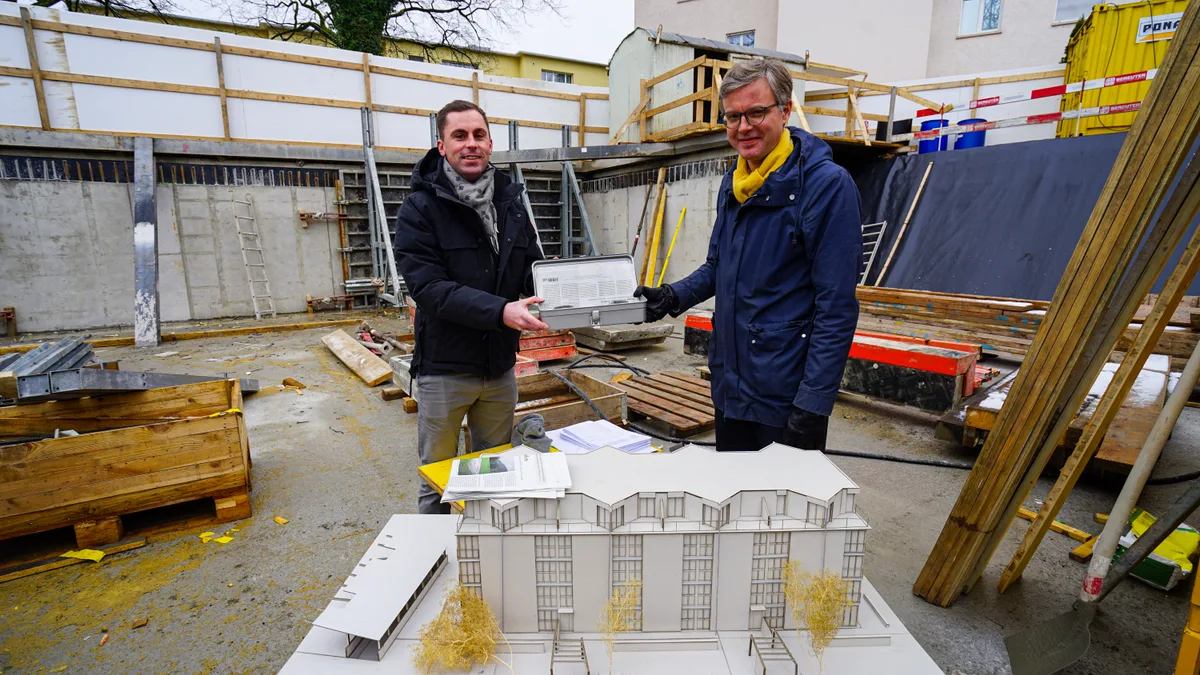 dsc04971 Christian Grewe (l.) und Christian Inderbitzin mit der Box, die im Rahmen der Grundsteinlegung in der Erde versenkt wurde., Darin enthalten sind eine Urkunde, eine Tageszeitung vom 27. Februar 2020 sowie ein Polaroid-Foto und zwei Automodelle., Die Projektverantwortlichen hoffen, dass die Box so schnell nicht mehr an die Oberfläche kommt., Deshalb wurde sie mit extra viel Beton überdeckt., Wo heute noch Schutt und Asche liegt, soll in rund einem Jahr dieses Gebäude stehen: Die Überbauung Wohnen im Park., Die Grünflächen wie auch das kronenartige Dachgeschoss seien besonders hervorzuheben, wie der verantwortliche Architekt sagt., Die Wohnungen sollen mit geringem Flächeverbrauch den grösst möglichen Komfort bieten..., ...und die Aussenräume können dank der Glasscheiben im Sommer wie auch Winter genutzt werden., Damit das Schlussresultat immer präsent ist, wurden die Visualisierungen und Grundrisspläne auf der Baustelle aufgehängt.