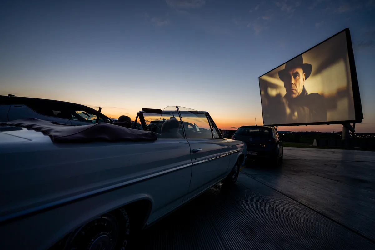 uster_27062020_autokino_crm_4 «Das perfekte Geheimnis» lockte zahlreiche Cineasten nach Dübendorf., Essen und Getränke gab's reichlich., Während die einen eher auf Chips unterwegs waren, ..., ... bemühten sich andere wiederum, althergebrachte Klischees zu bedienen., Am Ende sahen aber alle den gleichen Film., Entspannt vom Beifahrersitz aus und ..., mit Blick auf Leinwand und einen kitschig-schönen Sonnenuntergang.