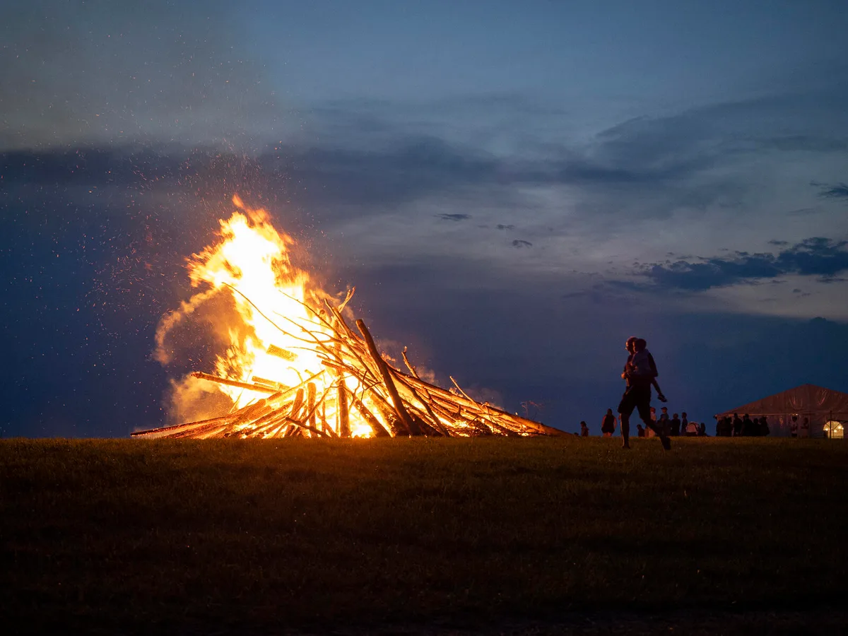 p8011112 Krönender Abschluss der Wildberger Bundesfeier: Das Entfachen des imposanten Höhenfeuers., Die Feier im Obere Luegeten stand jedoch unter besonderen Vorzeichen., Wegen Corona galten strikte Schutzmassnahmen., Zudem mussten die Gäste ihre Kontaktdaten angeben., Das hielt die Wildberger aber nicht vom Feiern ab., Für die musikalische Umrahmung sorgte die Gruppe «Echo von Wildberg»., Ganz zur Freude ihrer kleinen Fans., Das Singen der Nationalhymne fand draussen und mit genügend Abstand statt., Unter Anleitung zweier Musikerinnen wurden die Strophen gesungen., Anschliessend wurde das Höhenfeuer entfacht., Dieses beeindruckte nicht nur durch seine Grösse …, … sondern auch durch seine Hitze., Wegen der Trockenheit hielten Feuerwehrleute das Feuer in Schach., Die Gäste genossen das Spektakel …, … und zündeten fleissig Feuerwerk.