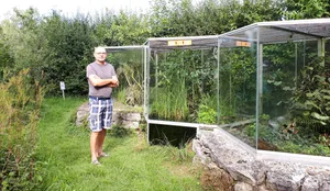 wanderung8 Ruedi Bärtschi, der Betreiber des Vivariums, vor den Terrarien im Garten., Das Gebäude des Vivariums kann man schnell übersehen., Im Vivarium kreucht und fleucht es: So auch im Teich, der immer mehr verlandet., Ruedi Bärtschi bei der Reinigung der Aquaterrarien., Dort ist auch der Feuersalamander zu Hause.
