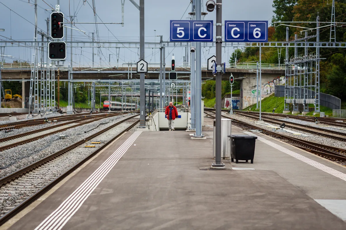 Die Strasse, die über die Gleise führt, soll saniert werden., Zeitgleich soll der provisorische Kreisel an der Brandrietstrasse durch einen Betonkreisel ersetzt werden.