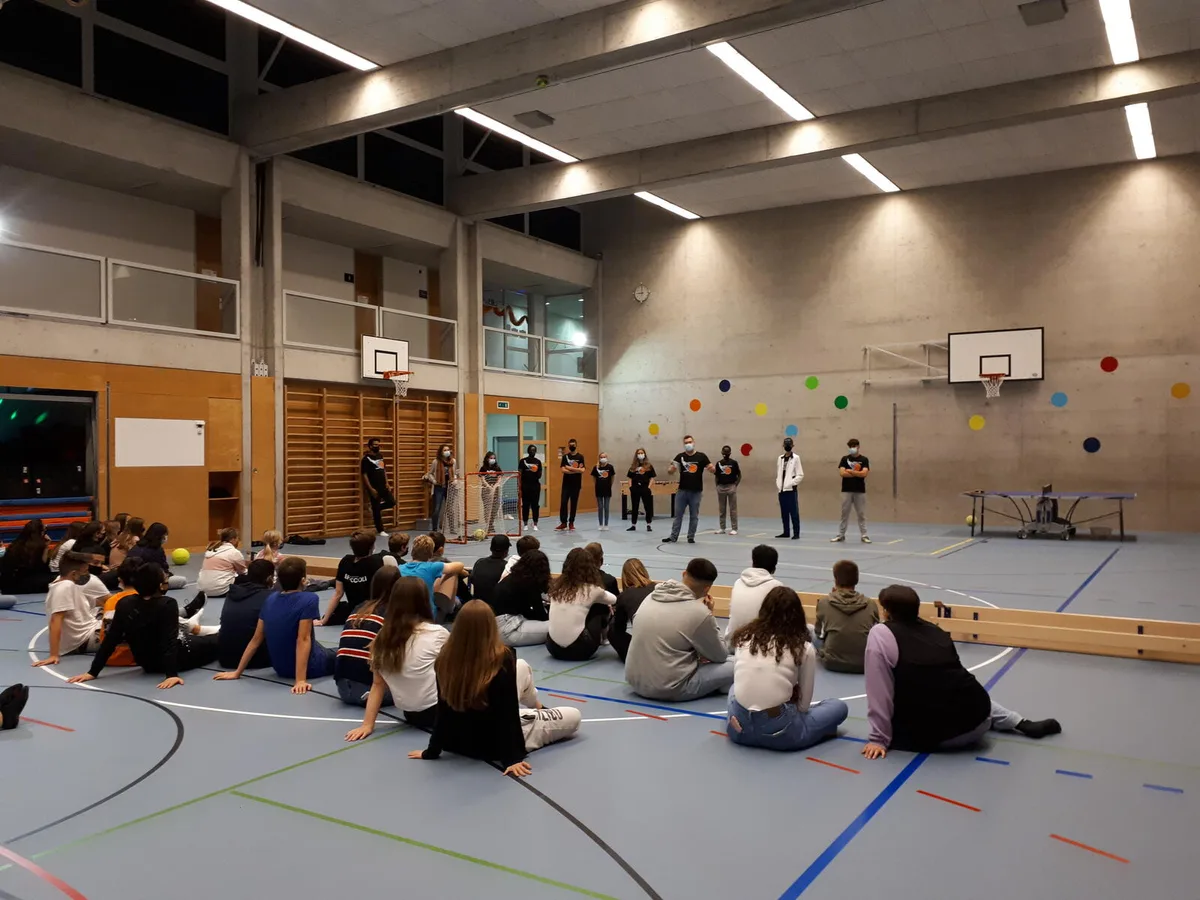 midnight2 Die beiden Co-Projektleiter und Coaches begrüssen die Teilnehmer und erinnern sie an die Regeln. , Die beiden Co-Projektleiter Ryan Hamilton und Angela Brüngger bei der Eingangskontrolle in der Turnhalle. , Wer nicht mitmachen will, der kann sich im Chill-out-Room entspannen... , … oder mit Kolleginnen und Kollegen plaudern. , Die beiden Coaches Emerson und Angelina bedienen den Kiosk, wo sich die Teilnehmer mit Snacks oder einem Getränk eindecken könne, Die Teilnehmer machen sich bereit fürs Völkerball.