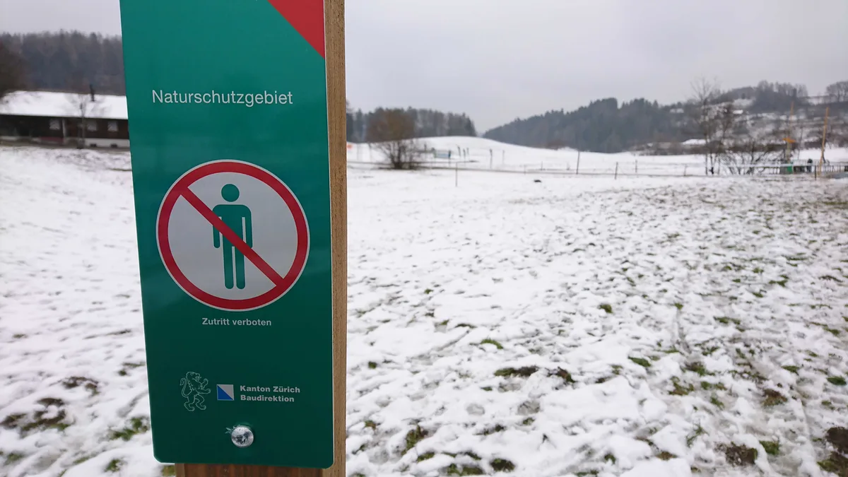 dsc_5732 Das Verbotsschild hielt scheinbar viele nicht davon ab, das Naturschutzgebiet dahinter zu betreten., Auf dem schneebedeckten Feld sind die Spuren gut zu erkennen., Mobiliar, hier eine Bühne, wurde ebenfalls dort platziert., Gemeindeschreiber Christian Schmid nennt Gründe, wie es zum Malheur kommen konnte.