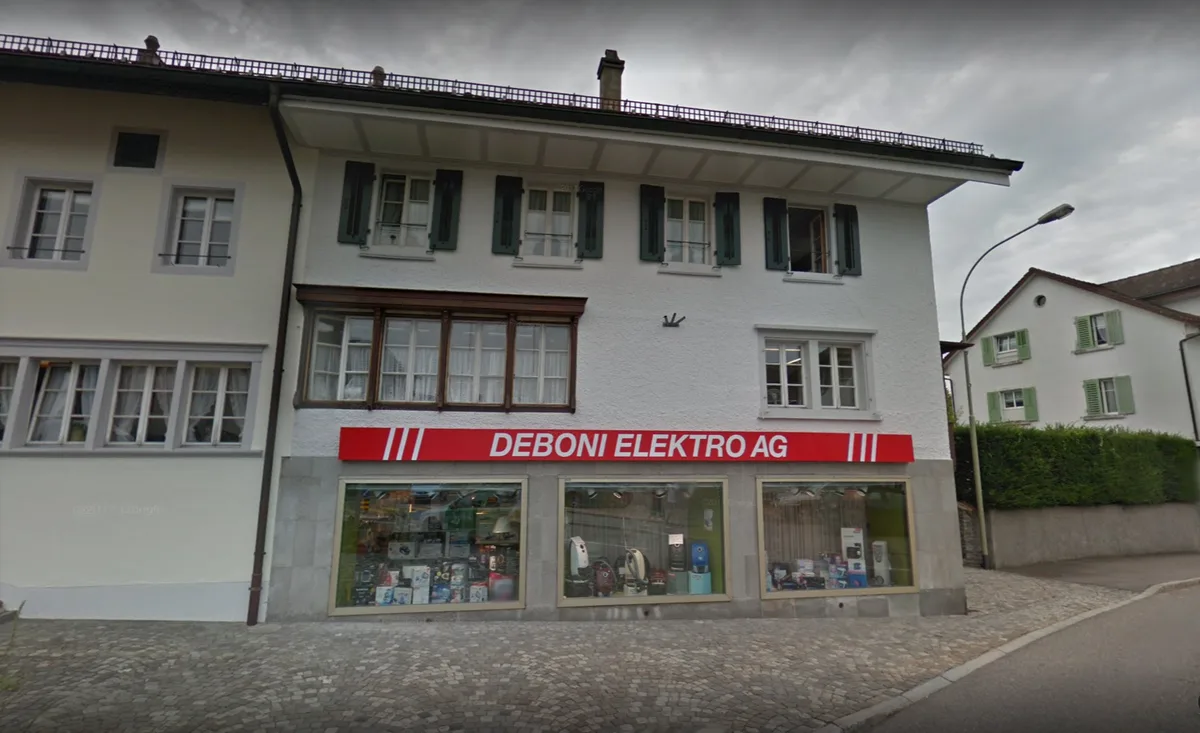 de_boni_screenshot Ab 1. April gehört Deboni Elektro in Hinwil zur Baumann Koelliker Gruppe., Etwas Wehmut schwingt mit: Die bisherigen Inhaber Armin Pfiffner und Brigitte Deboni verkaufen ihre Firmenanteile. Aber...., ... sie bleiben vorerst Geschäftsführer. Rechts neben ihnen: Frank Gerber und Bruno Huonder von der Baumann Koelliker Gruppe.