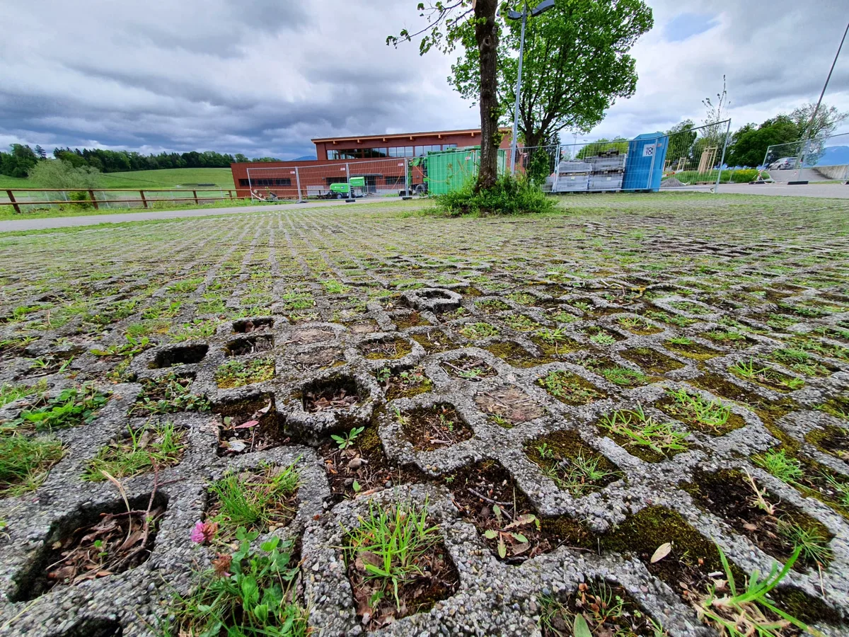 whatsapp_image_2021-05-17_at_13-19-23 Die Gittersteine sind teils gebrochen., Während der Bauarbeiten war der Parkplatz stark beansprucht., Nun, da die Halle praktisch fertig ist, hat der Gemeinderat über die Sanierung befunden.