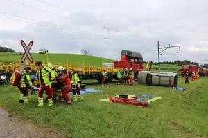 a_1_r_img_5112 Ein «Verletzter» aus einem der beiden Autos, die in den «Unfall» mit dem Bauzug verwickelt waren, wird abtransportiert., Die Feuerwehr öffnet eines der «Unfallautos», um einen Zugang zu den «verletzten» Passagieren zu schaffen., Eine Notärztin, ein Notarzt und eine Rettungssanitäterin widmen sich zwei «Patienten»., Ein «Verletzter» liegt erstversorgt zum Abtransport bereit., Und bald darauf läuft der Abtransport der «Patienten» ..., ... zu den bereitstehenden Rettungswagen.