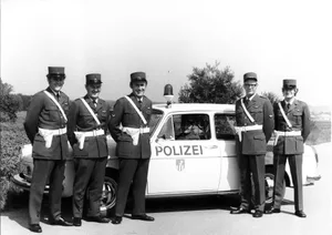 stadtpolizei_duebendorf Gruppenbild mit Dienstwagen, mit im Bild ist der erste Dübendorfer Gemeindepolizist Gotthilf Ammann (2. von rechts)., Das Dübendorfer Polizeikorps vor dem Polizeiposten an der Wilstrasse (undatierte Aufnahme).