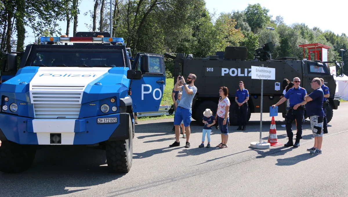 aa_1_b_r_img_5176 Die Kantonspolizei zeigte Fahrzeuge wie den gepanzerten Mowag Eagle (links) und den Duro, die man sonst nie von Nahem sieht., Die Vorführung der Diensthunde stiess auf grosses Zuschauerinteresse., Zwei Generationen Patrouillenfahrzeuge: Der alte VW Käfer «weisse Maus» und der neue, mit Strom betriebene Audi e-Tron 55., Ebenfalls zu Gast in Hinwil: ein Wasserwerfer … , … und die Seepolizei mit ihrem grossen Unimog für Spezialeinsätze., Fototermin auf dem Polizeitöff: eine Attraktion für Kinder und ihre Eltern., Welche Waffen sind erlaubt, welche verboten? Ein Experte gab Auskunft., Auch das Tiefbauamt stellte seine Gefährte aus, etwa diese grosse Wischmaschine, …, … aber auch kleinere Arbeitsgeräte., Winter im Sommer: Kinder nutzten das imposante Streusalzdepot des Tiefbauamts als Mega-«Sandhaufen».