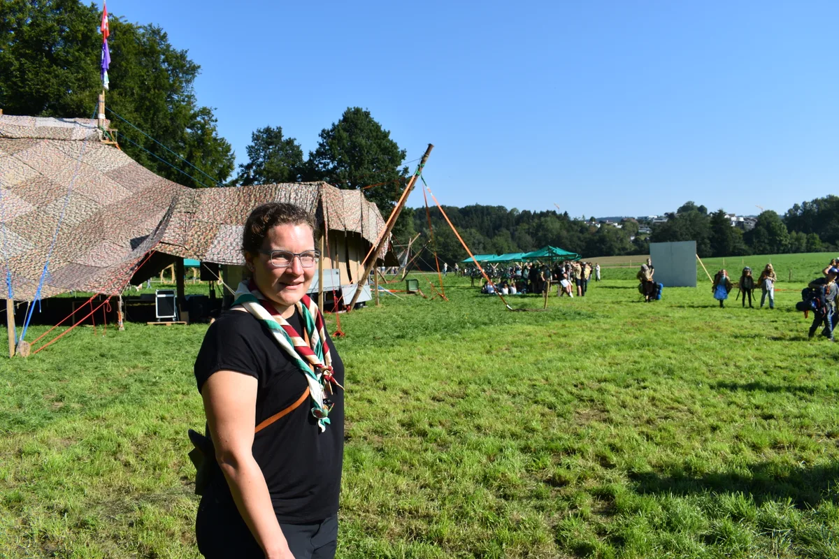 pfadi1 OK-Chefin Anja Koch hat drei Jahre an der Planung der Pfadi-Landsgemeinde mitgearbeitet und freut sich nun auf die Durchführung., Ein Blick auf den Turm, der das Zelt trägt. Auf der ersten Plattform befinden sich die Steuerungen für Licht und Sound., Geschminkt und verkleidet wartet eine Schar Pfadis auf die Eröffnung der Landsgemeinde im Zelt., Wenn das Motto Hollywood lautet, dar am Eingang zum Gelände der rote Teppisch natürlich nicht fehlen., Ok Mitglied Maxim Morskoi an der Arbeit beim Informationsdesk., Auf dem Gelände der Landsgemeinde weisen Schilder den Weg zum gesuchten Ort., Flurin Kümin auf dem Zelt-Turm. Er hat eine Woche lang in den Aufbau der Infrastruktur für die Landsgemeinde investiert.., Sticker und Aufdrucke auf dem Hemd zeugen von den Teilnahmen an verschiedene Pfadi-Treffen.