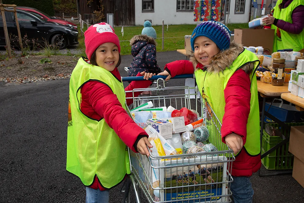 Auch die kleinen Helferinnen und Helfer hatten Spass., Das Helfer-Team von Wila startete motiviert in den Tag., Vorgedruckte Einkaufszettel halfen den Spendern, das Richtige zu kaufen., Ladenkunden übergaben nach dem Einkauf ihre Spenden an die Helfer., Jeder Spendenkorb sorgte für Freude., Immer wieder kamen neue Spenden hinzu., Langsam füllte sich der Spendentisch., Die Spenden wurden in Kartons verpackt., Die Spenden wurden in Kartons verpackt., Die Schachteln wurden feinsäuberlich verschlossen., Anschliessend wurden die Kartonschachteln in Geschenkpapier gewickelt., Anschliessend wurden die Kartonschachteln in Geschenkpapier gewickelt., Dabei bewährte sich die Teamarbeit., Auch bereits fertig verpackte Päckli wurden abgegeben., Das Helfer-Team vor der Migros in Turbenthal.
