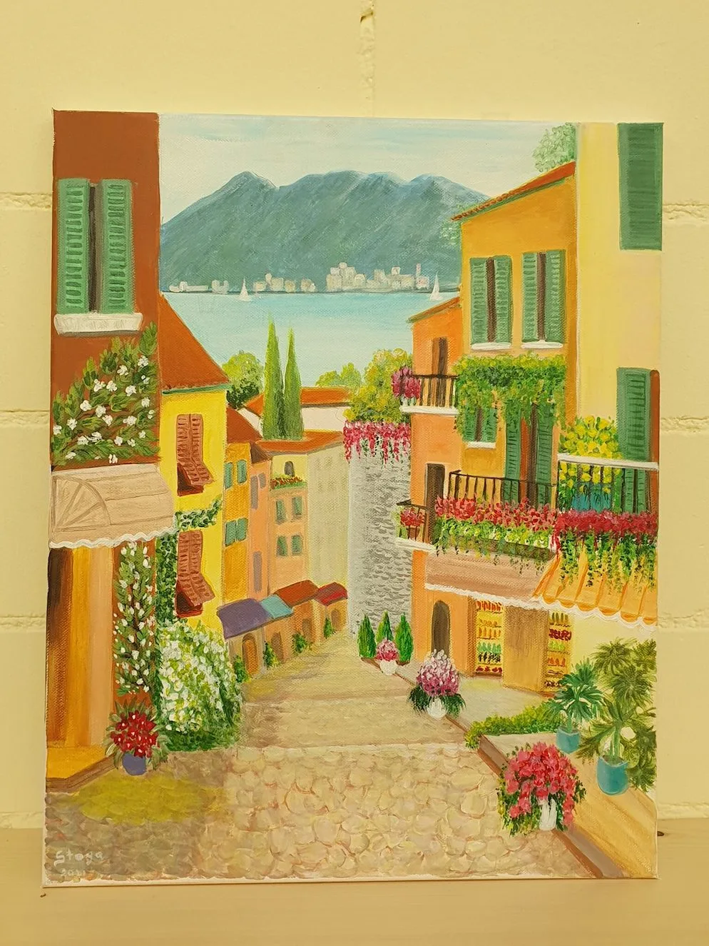 Man sieht ein Bild von Stojanka Oberholzer, einer Künstlerin aus Steg. Sie hat eine Gasse mit Häusern gemalt.