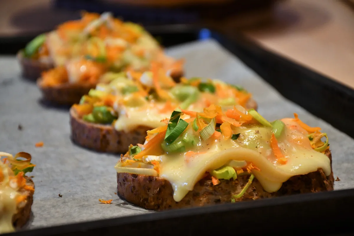 Diese Käseschnitten eignen sich ideal, um die Raclette-Reste der Feiertage zu verwerten., Die Schnitten werden mit saisonalem Gemüse garniert, und dann ab in den Ofen., Schmeckt lecker und ist schnell und mit wenig Aufwand zubereitet.