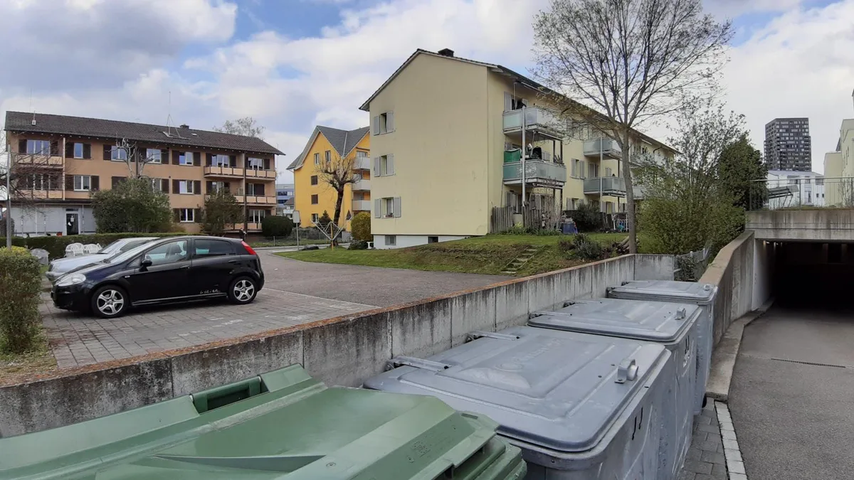 Überbauung im Birchlen-Quartier mit günstigen Wohnungen, Wiese und vielen Parkplätzen.