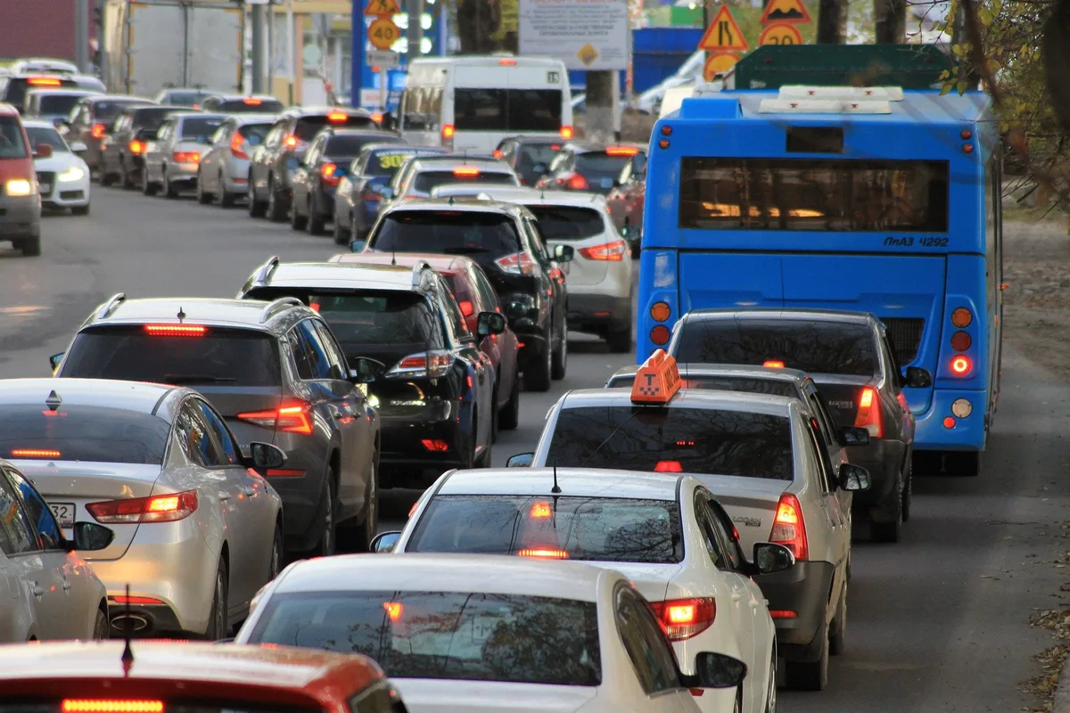 Stau auf einer zweispurigen Strasse mit zahlreichen Autos und einem blauen Bus.
