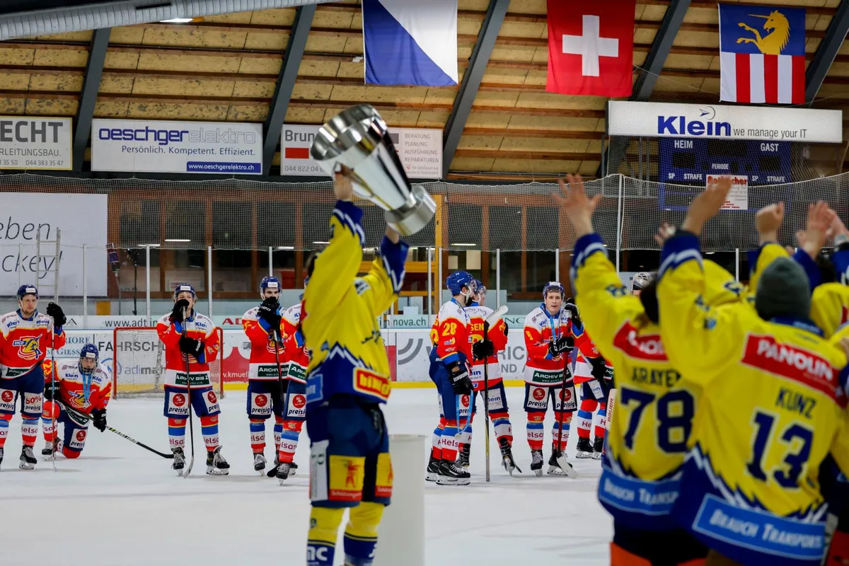 Der EHC Dübendorf muss zusehen, wie der EHC Arosa die Cup-Trophäe stemmt., Für Captain Silvan Hebeisen und den EHCD war es eine äusserst bittere Niederlage., Genug Chancen hätte der EHCD (hier Steven Widmer) gehabt., Zweimal jubelten die Dübendorfer über den Führungstreffer., In der Schlussphase musste EHCD-Torhüter Remo Trüb zwei Gegentreffer hinnehmen., Damon Puntus hatte den ersten Treffer der Partie erzielt. Am Ende blieb auch ihm nur der Frust., Über die Silbermedaillen können sich EHCD-Trainer Reto Stirnimann (rechts) und sein Assistent Christian Krähenbühl nicht freuen.