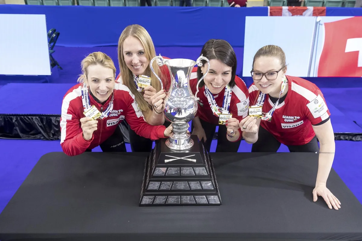 Curlerin Esther Neuenschwander (Gockhausen) posiert mit ihren Teamkolleginnen und dem WM-Pokal.
