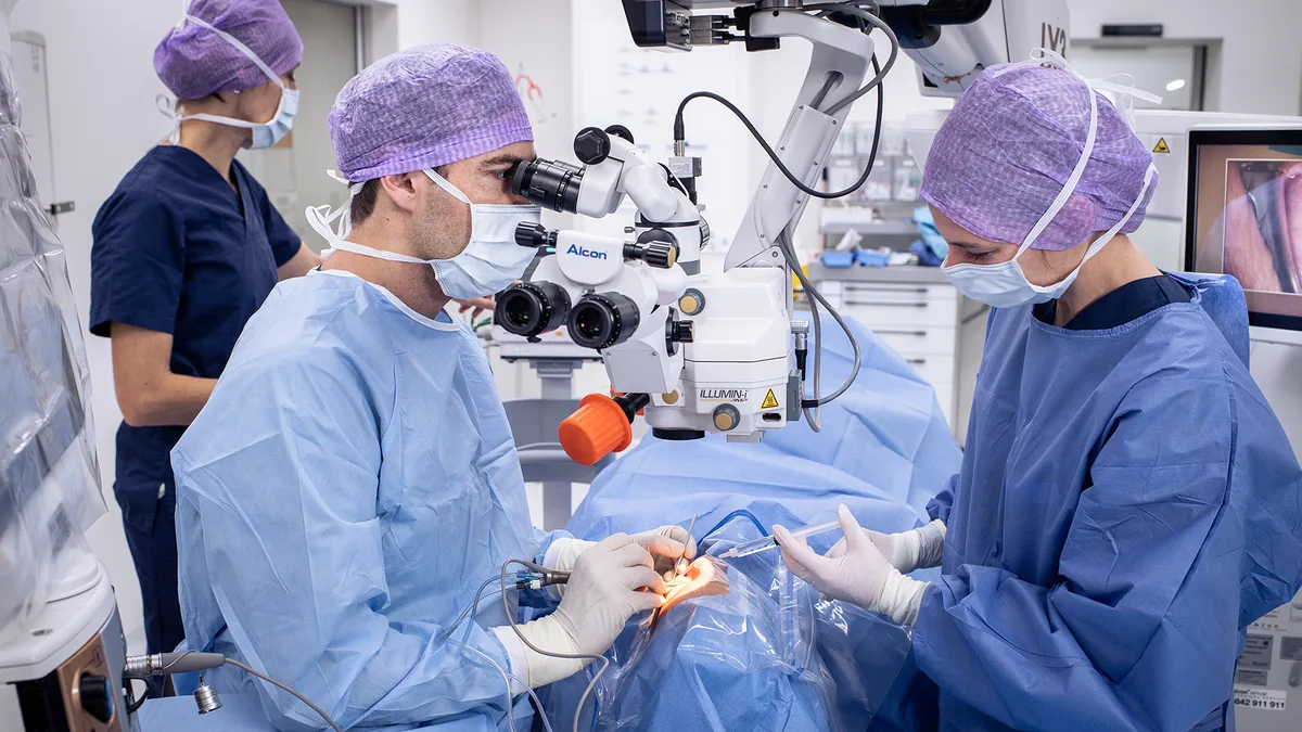 Augenarzt Dr. med. Darius Madjdpour führt in einem Operationssaal eine Augenoperation durch.