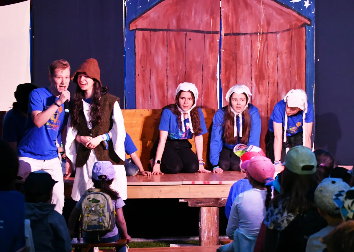 Theaterstück zum Auftakt: Die Geschichte des verlorenen Schafs., Geschichten über Gott: Die Handpuppen Jimmy und Lucy fassen das Thema zusammen., Gewisse Leiterinnen hatten selbst einst als Kinder an der Erlebniswoche teilgenommen., Kinder freuen sich nach einer Pause der Erlebniswoche über neue Abenteuer. , Fangenspielen wurde der Grösse der Teilnehmer angepasst.