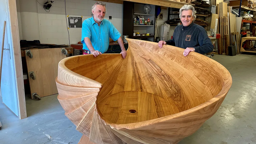 Die Gründer der Traumbad GmbH, Hansruedi Büchler und Norbert Lohrer, stehen hinter einem Modell ihrer Holzbadewanne.