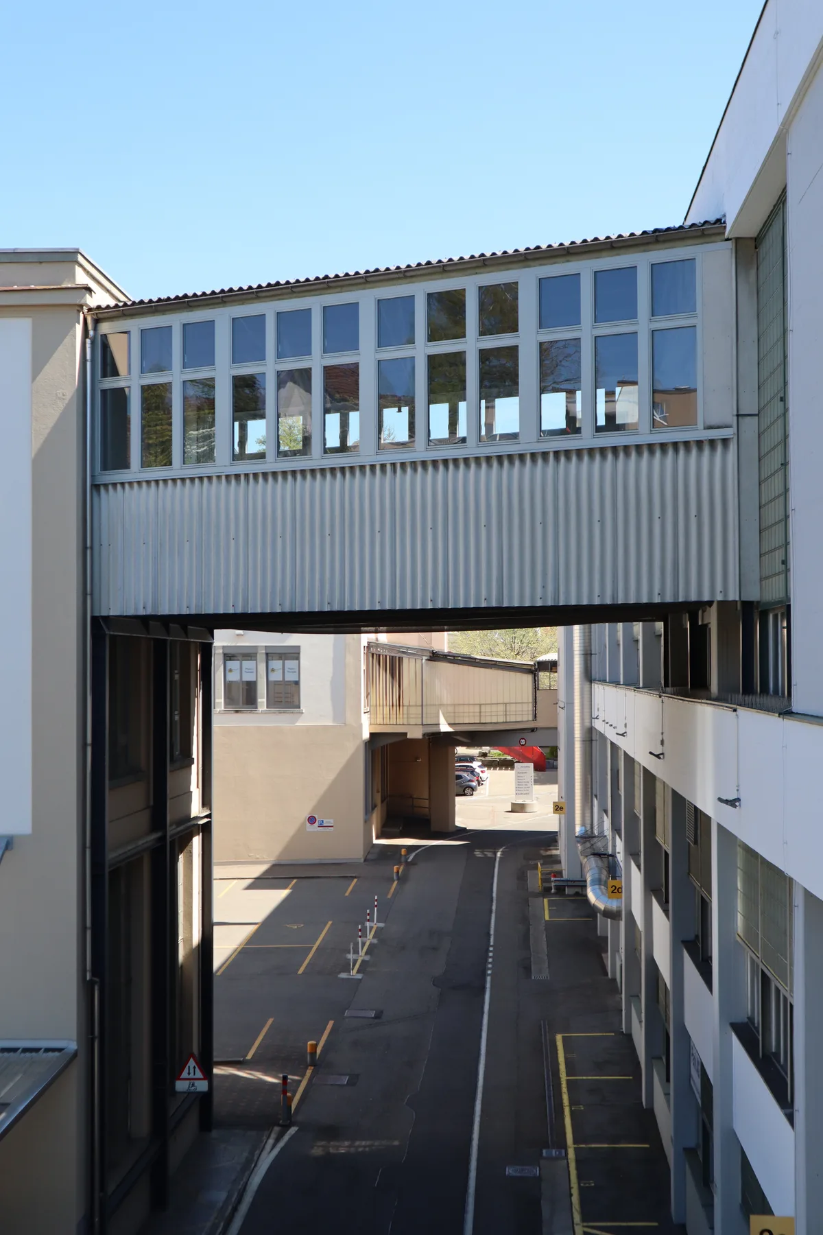 Zwei Passerellen, eine im Vorder- und eine im Hintergrund, die verschiedene Industriegebäude miteinander verbinden.