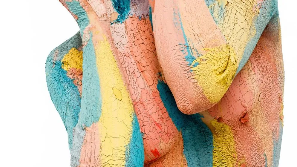 Ein mit bunter Farbe bemalter Frauenkörper. Die Arme sind vor die Brüste gelegt.