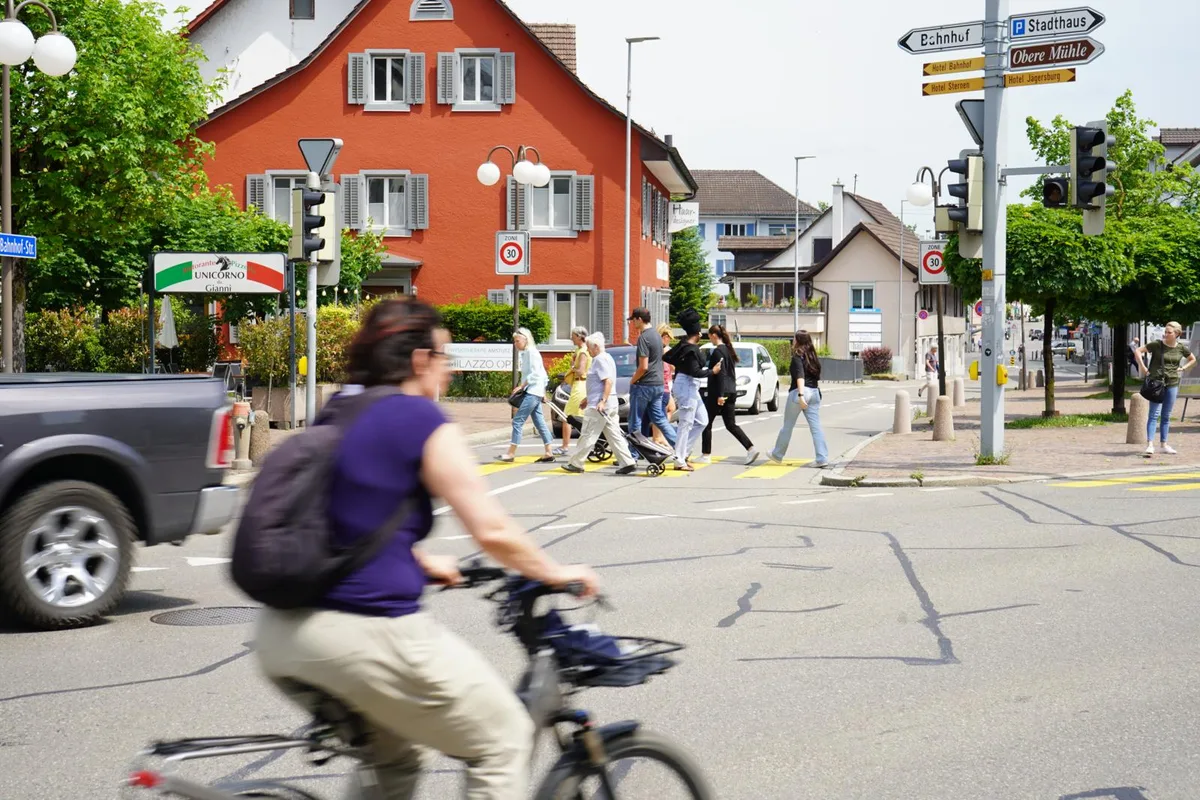 Fussgänger gehen über eine Strasse bei der Städtlikreuzung im Zentrum Dübendorf.