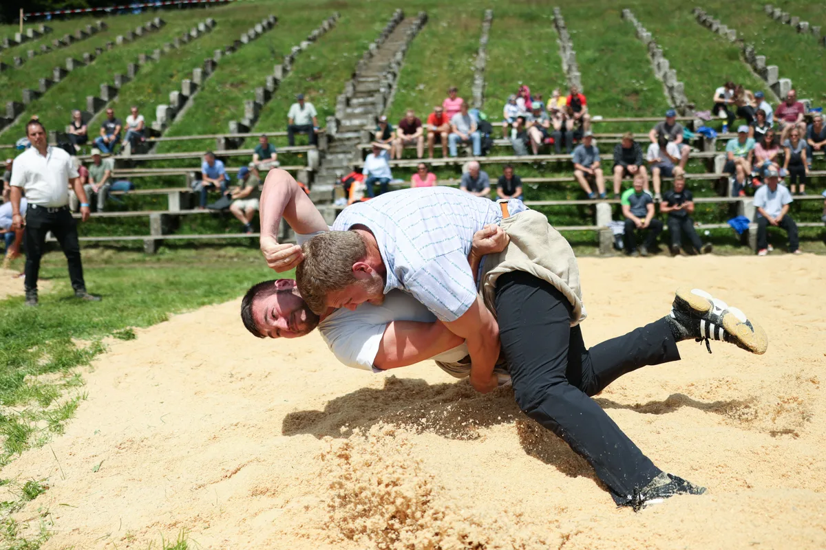 sport_11072021_schwingenbachtel_dku_14 Szene aus dem letztjährigen Bachtelschwinget. Am Sonntag treffen sich die «Bösen» wieder auf dem Oberländer Hausberg., SKZO-Präsident Daniel Spörri (links, mit Vorjahressieger Kindlimann) hofft, dass der frühe Termin namhaftere Schwinger anlockt., Auch mit attraktiven Gaben wollen die Oberländer punkten: Stefan Burkhalter (Sieger 2014) mit Siegermuni., 2021 verzichtete man wegen der Pandemie auf externe Zuschauer. Heuer werden die Ränge besser gefüllt sein.
