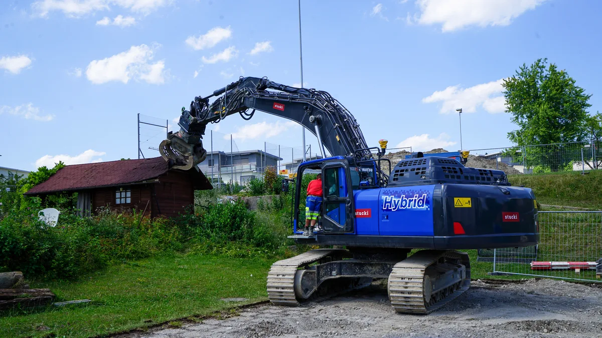 Ein Bagger bei der Baustelle der neuen Sporthalle russikon