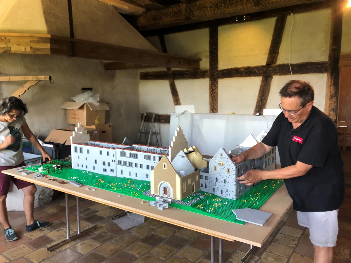 lego2 Doris und Daniel Hunziker stellen das Lego-Ritterhaus, gebildet aus 70 000 Steinchen, in Bubikon auf., Doris Hunziker kümmert sich ums Drumherum vor dem Ritterhaus.