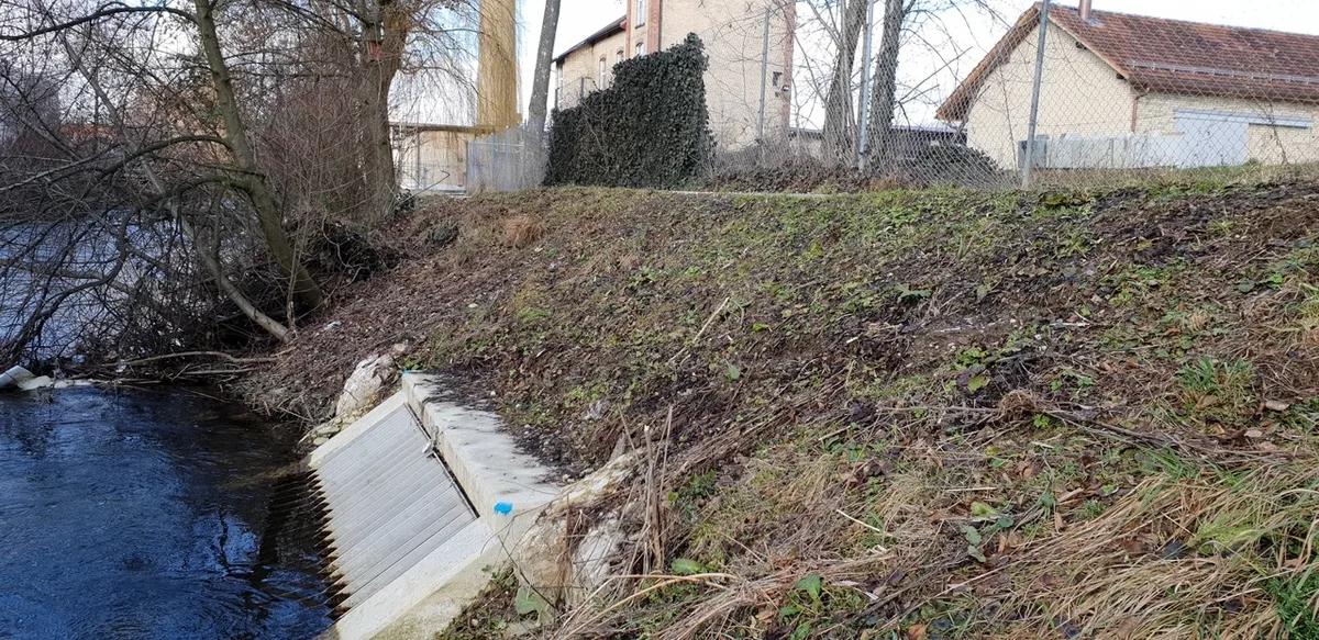 Eine Wasserfassung aus Metall ist am Ufer der Glatt verbaut. 