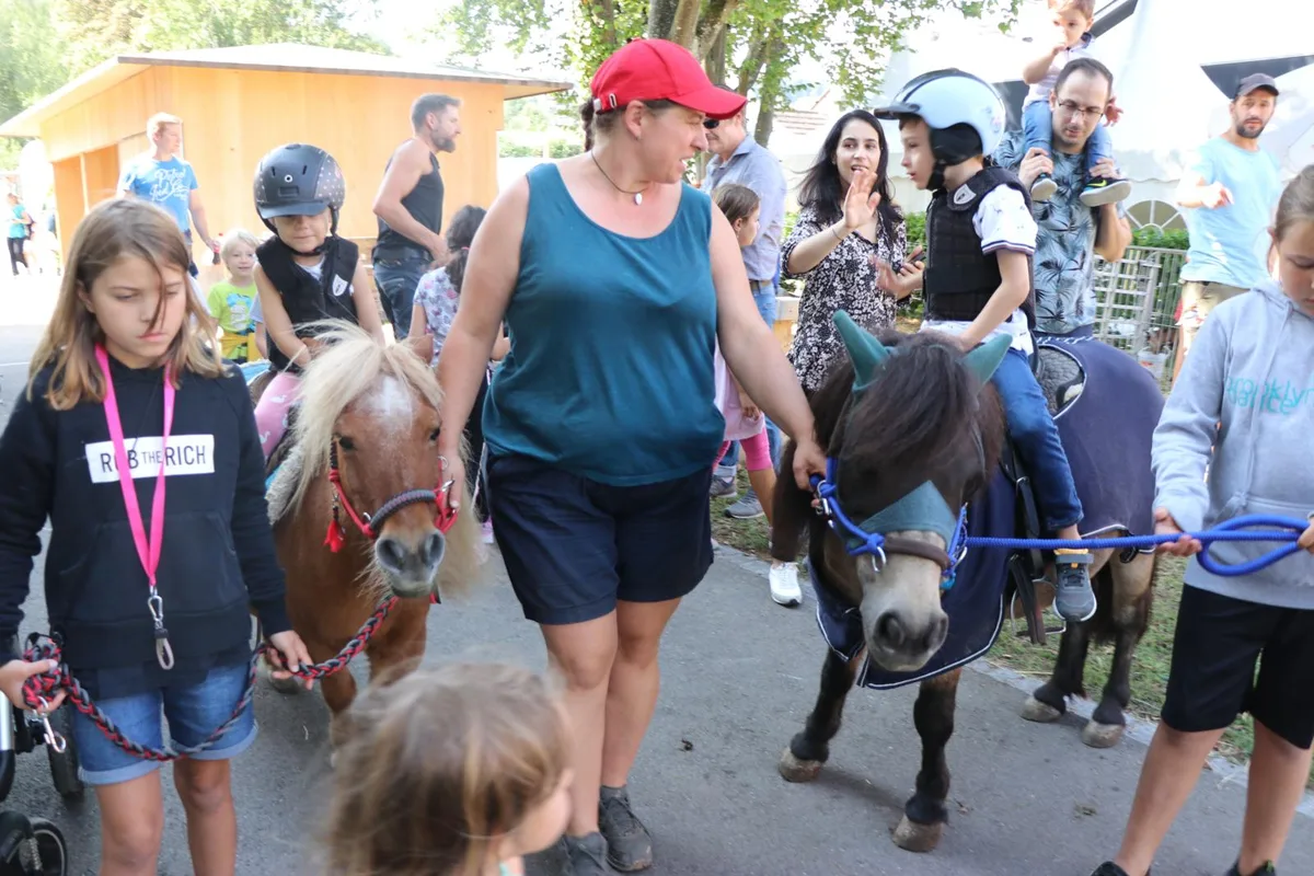 Ponyreiten gehört zu den beliebtesten Attraktionen am Sommerfest., Der Chilbibetrieb wurde dieses Jahr vergrössert. , Auch im Jahr 2022 gilt: Kein Fest ohne Wurst vom Grill. , Ballontierli formen – eine Kunst für sich. , Diese zwei Jungs nehmen das Ziel genau ins Visier.