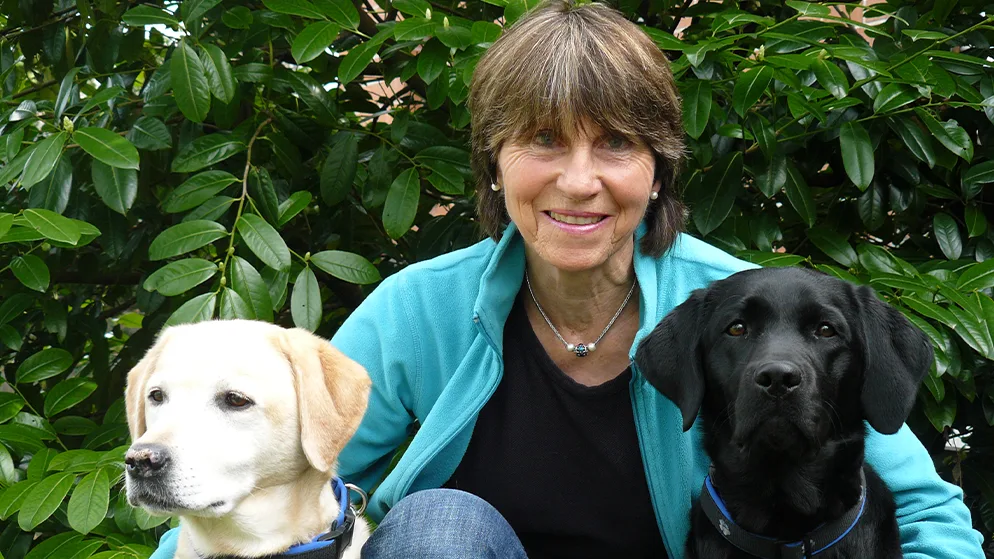 Man sieht Peggy Hug, Teamtrainerin bei Therapiehunde Schweiz, mit ihren Labradorhunden Aischa und Nera