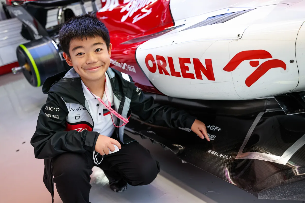 2022_japanese_grand_prix_-_sunday Der grosse Moment des kleinen Jungen: «Danke Goto», bedeuten die japanischen Schriftzeichen., Vor drei Jahren hatte er Teamchef Frédéric Vasseur einen Umschlag zukommen lassen., Das Team machte ihn ausfindig - und erfüllte ihm einen Traum., Goto posiert mit den Fahrern Valtteri Bottas und Zhou Guanyu.