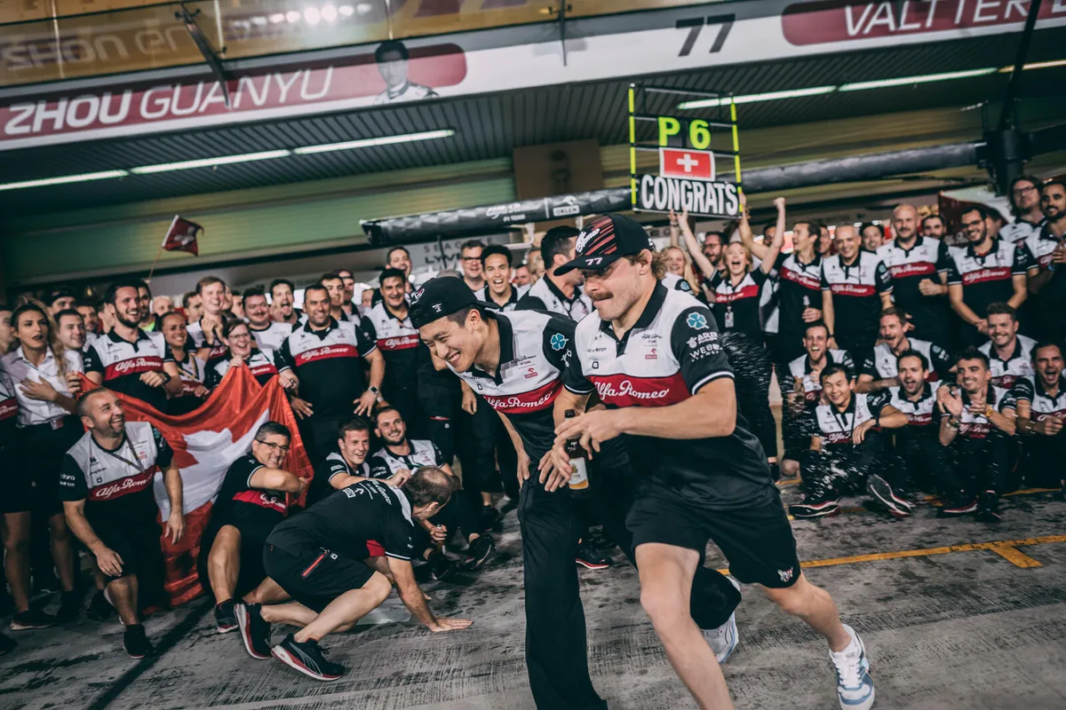 2022_abu_dhabi_grand_prix_-_sunday Die Sauber-Piloten Valtteri Bottas (rechts) und Zhou Guanyu feiern mit dem Team – und flüchten vor der Champagnerdusche.