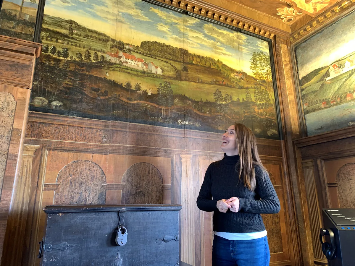 Museumsleiterin Florence Anliker zeigt ein Wandbild mit dem Ritterhaus Bubikon.