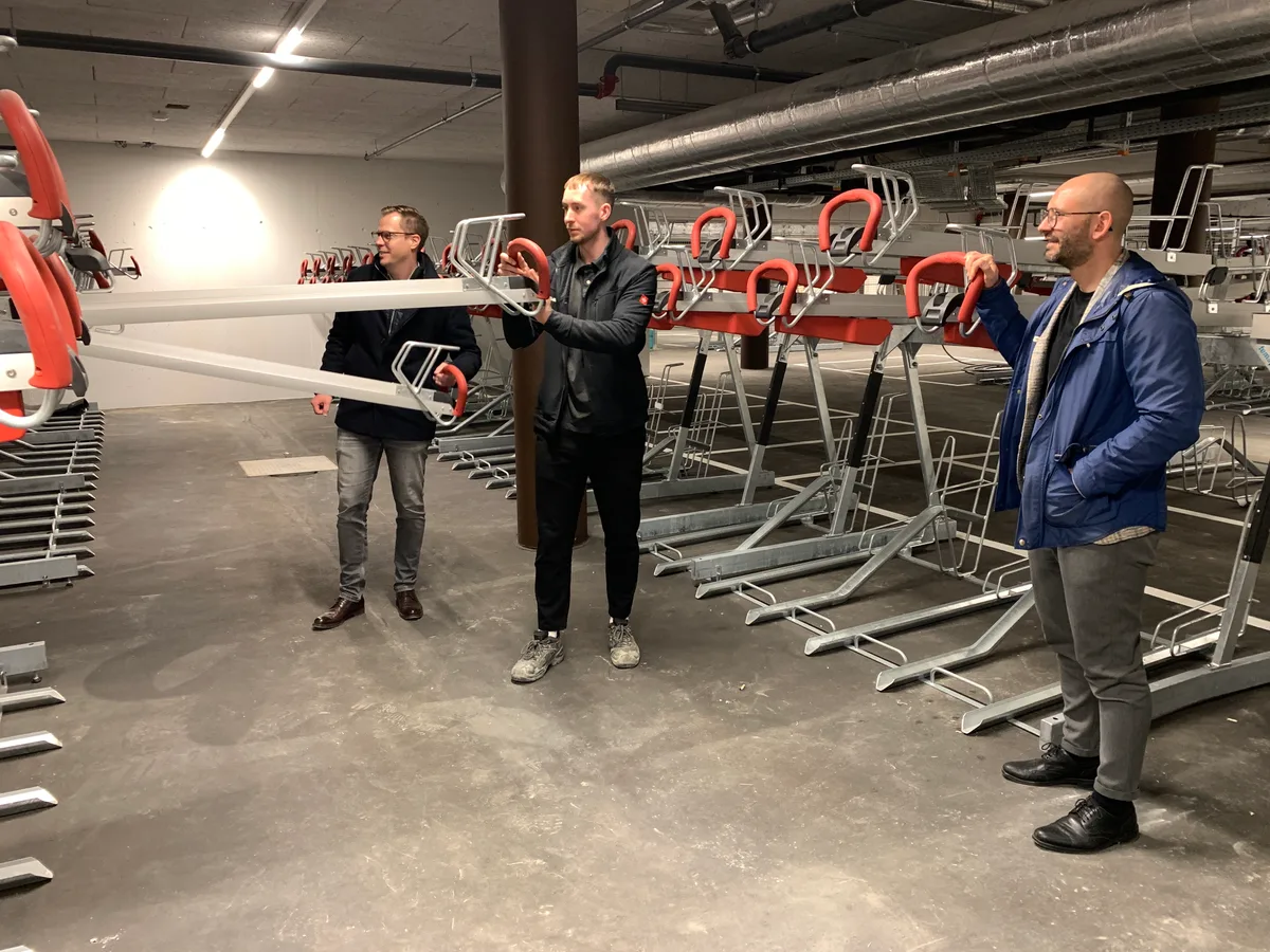 Drei Männer stehen in einem grossen Velokeller.