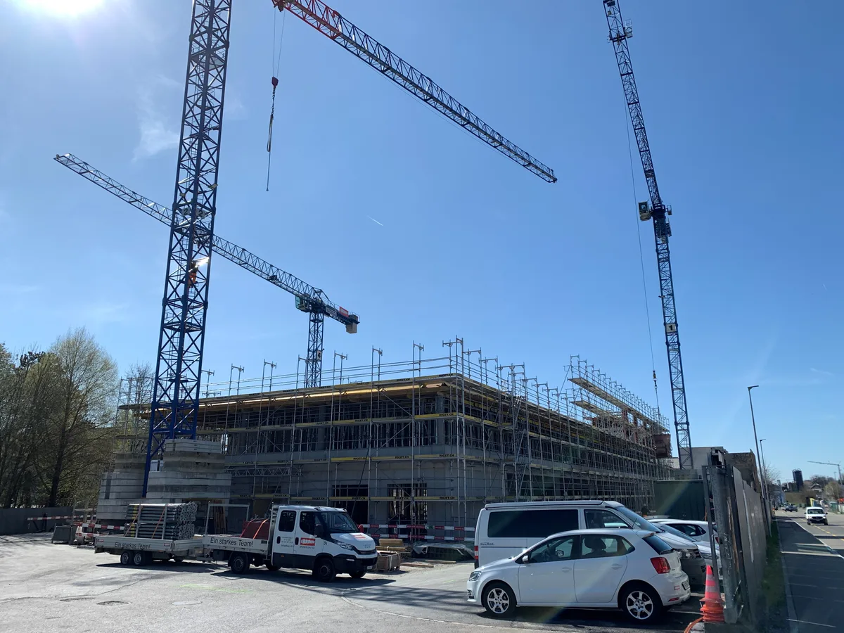 Baukräne stehen an einer Baustelle.