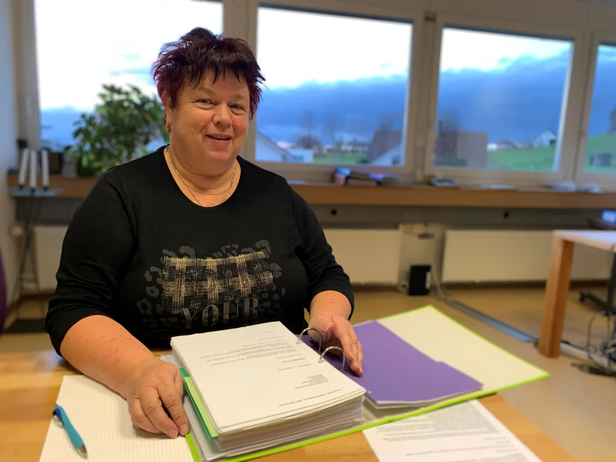 Barbara Schnyder sitzt am Tisch und hat einen Ordner vor sich.