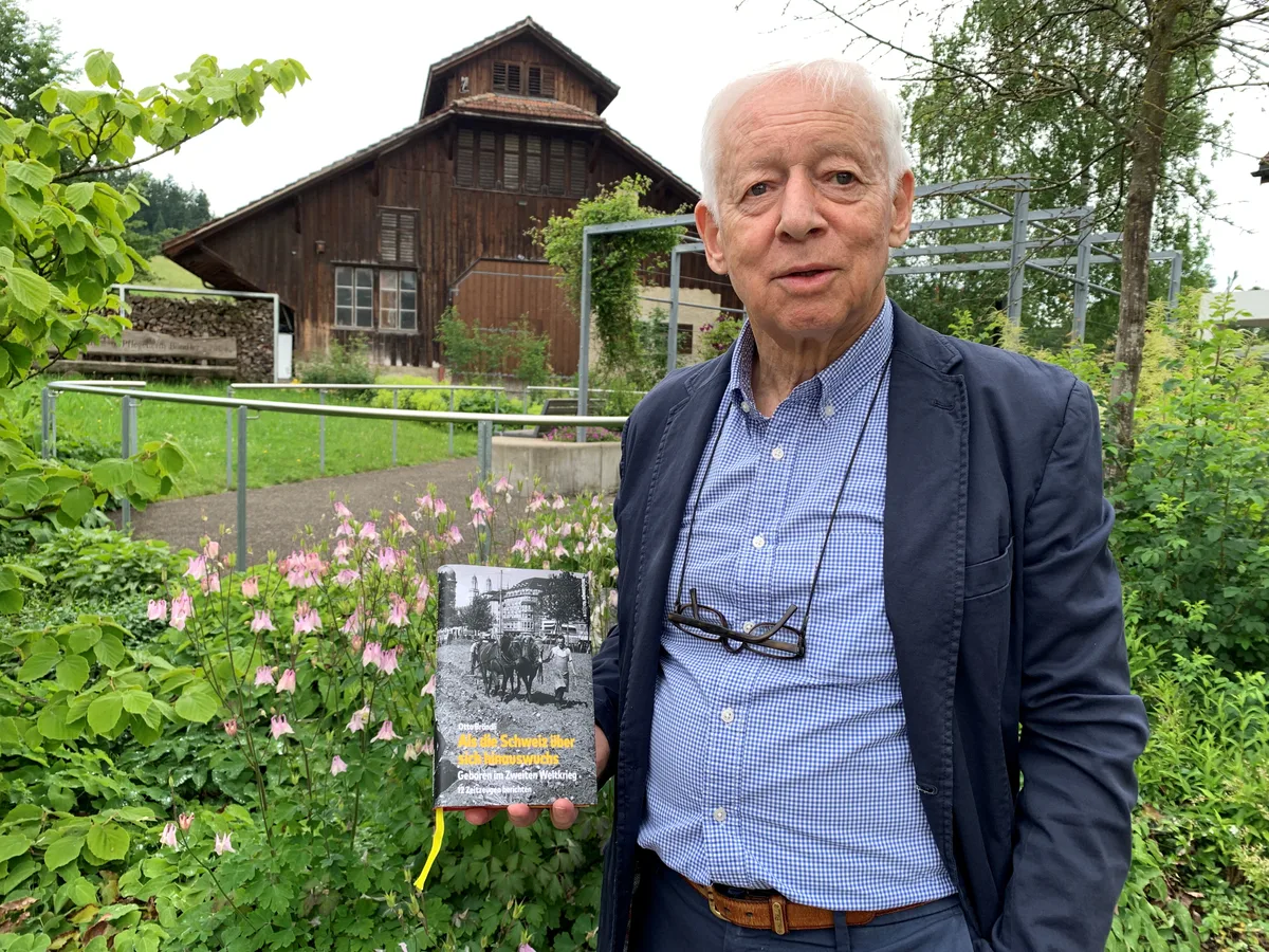 Ein Mann posiert mit einem Buch.