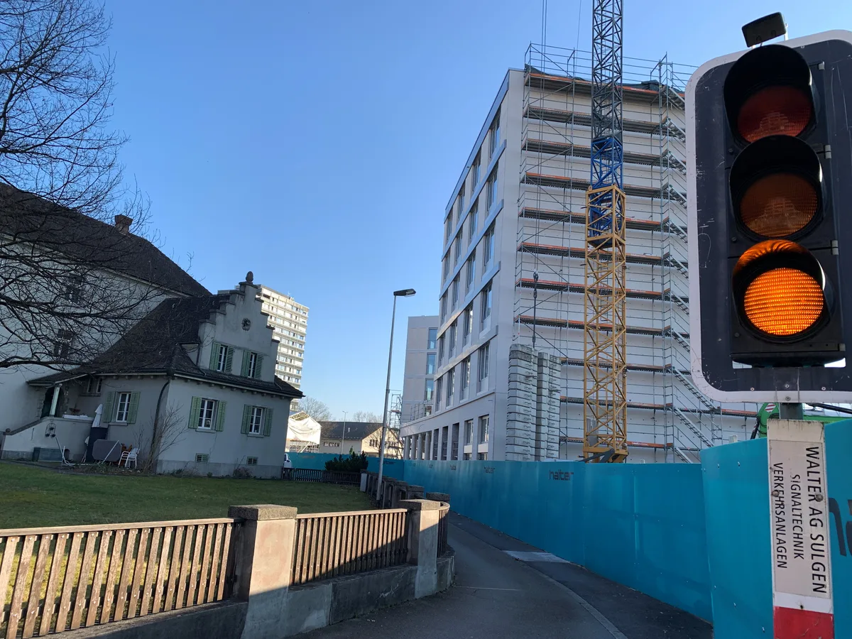 Bauen mit Nachbarn: Die Zufahrt zu den Parkplätzen des Gerichts ist jetzt über eine schmale, signalgesteuerte Passage möglich. Wenn der Kanton bauen wird, dürfte es hier vorübergehend auch wieder sehr eng werden. Ein Lichtsignal steht zwischen mehreren Häusern.