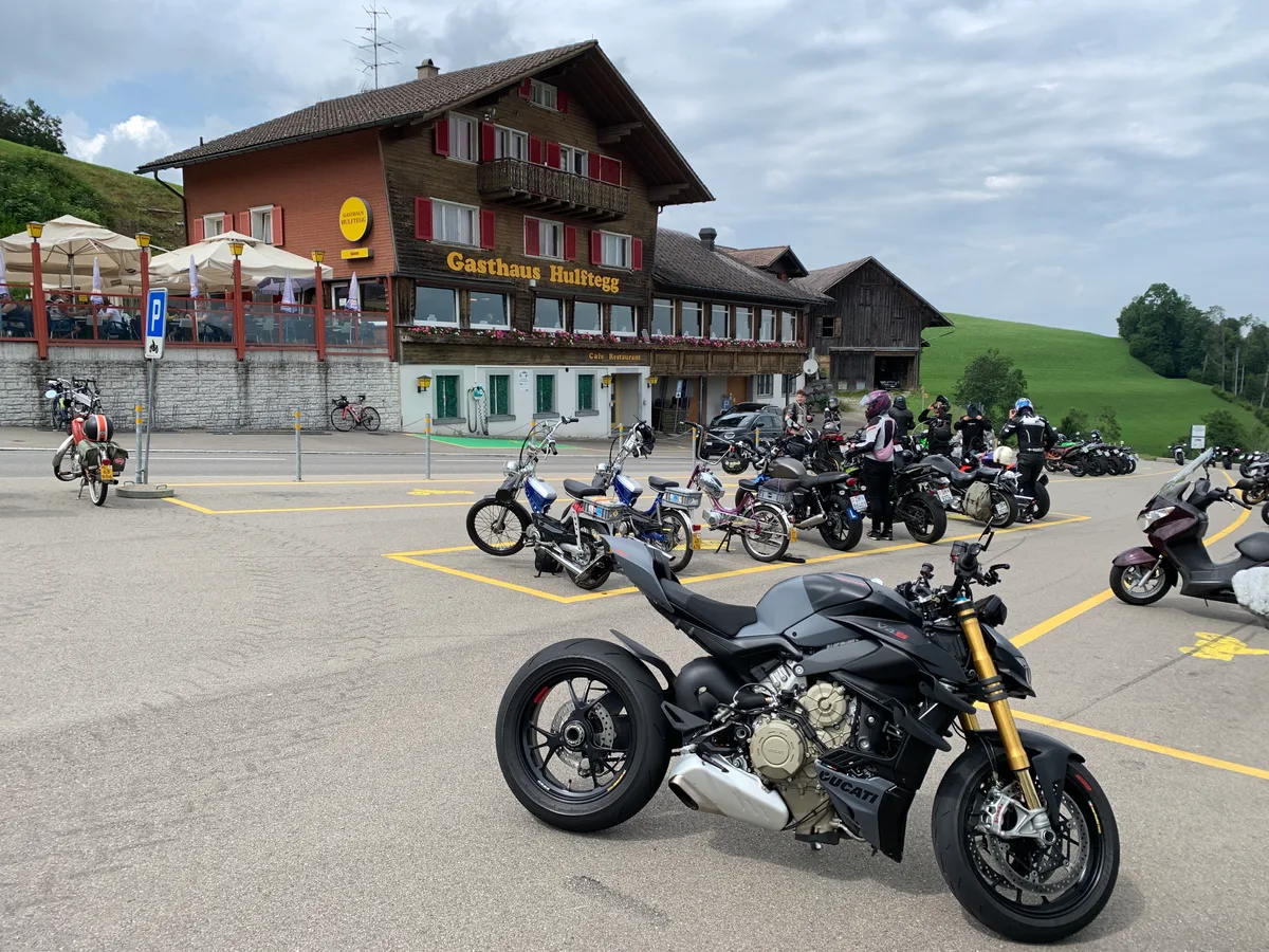 Motorräder und Töffli stehen auf dem Parkplatz vor dem Gasthaus Hulftegg.