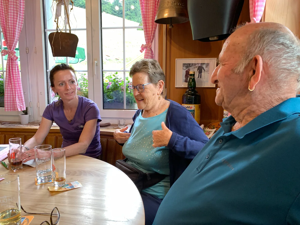 Drei Leute sitzen am einem Restauranttisch. 