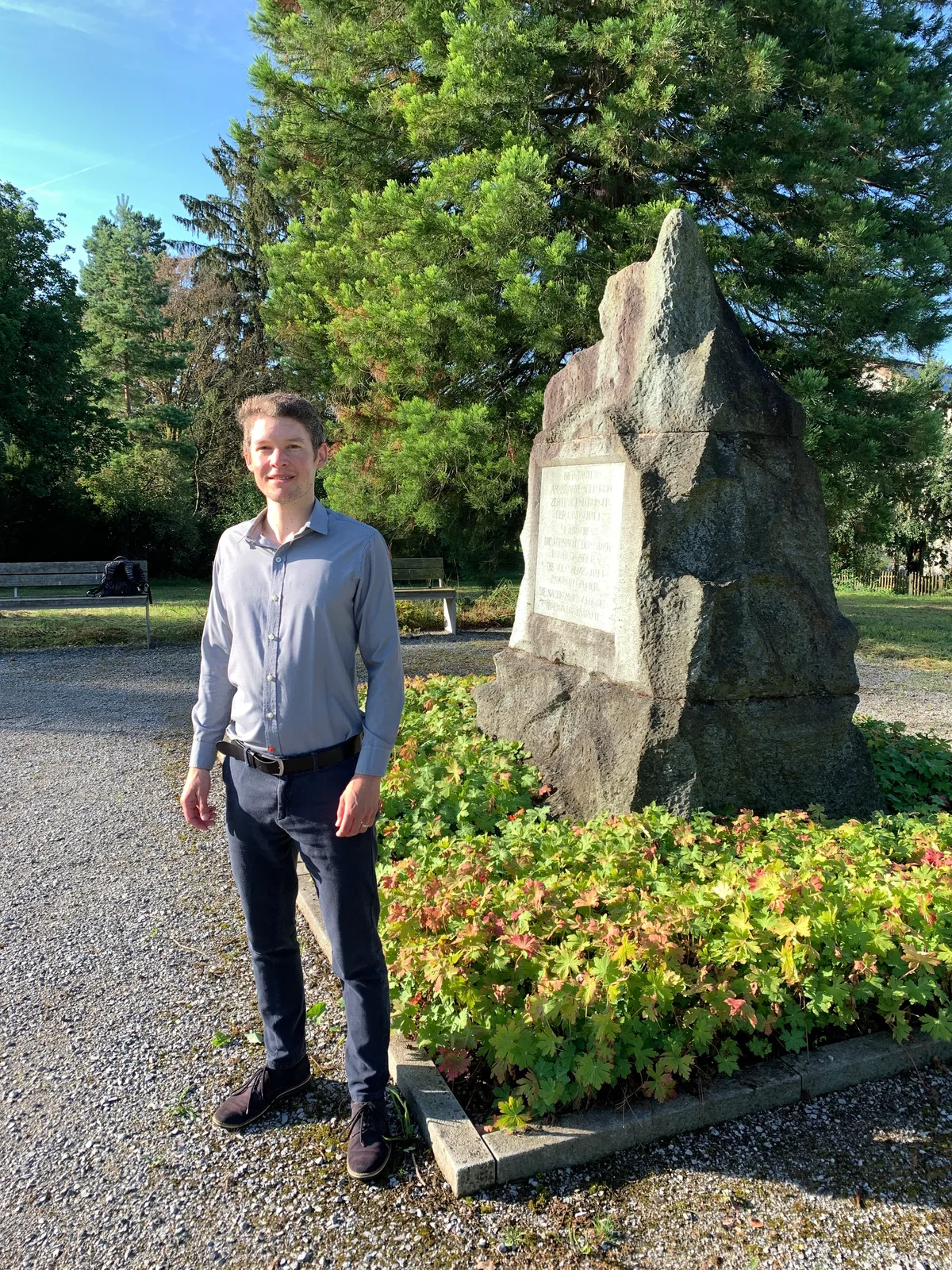 Ustertag-Stein auf dem Zimikerhügel in Uster und davor der Journalist Lukas Leuzinger.