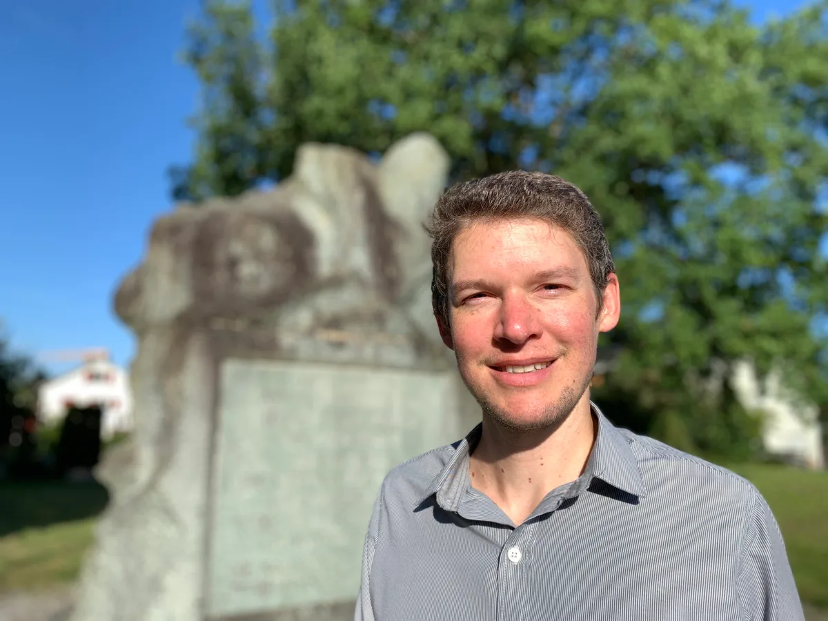 29956034-3 Ustertagstein auf dem Zimikerhügel in Uster mit Schloss und Kirche im Hintergrund und Lukas Leuzinger, der eine Arbeit über die Unterzeichner des Memorials von Uster schreibt am 9. August 2024