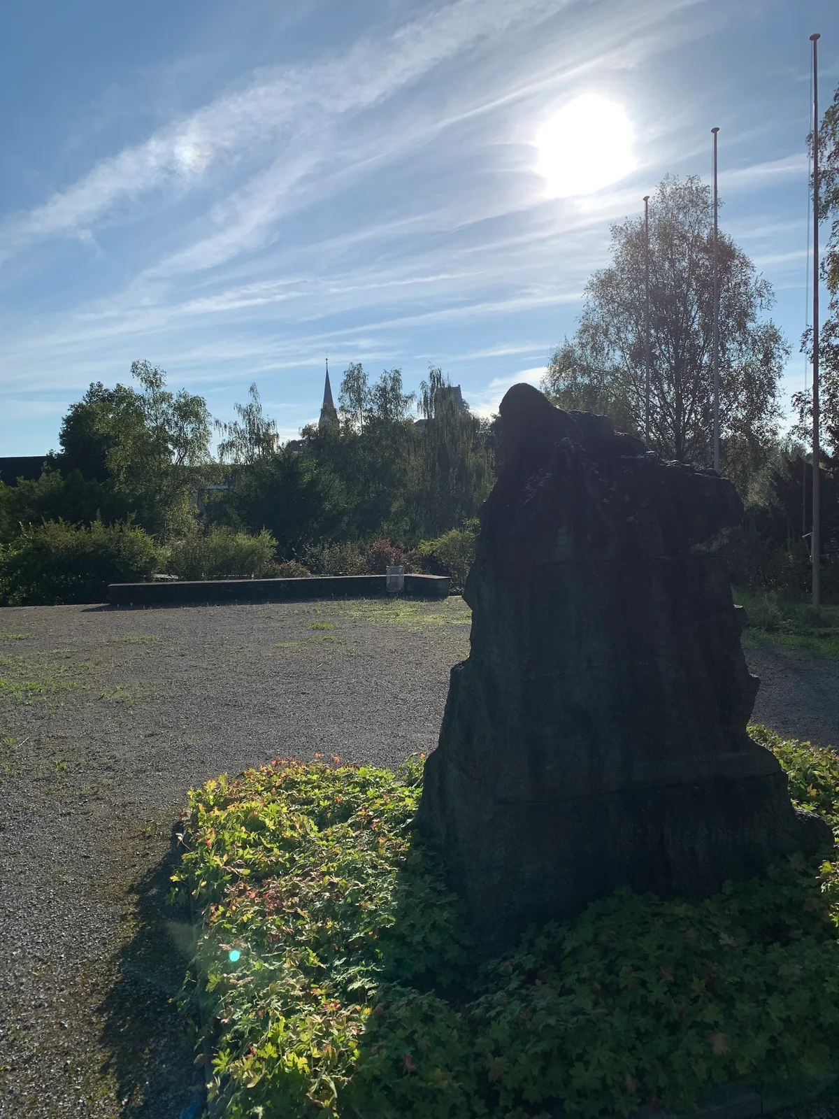 Der Ustertag-Stein auf dem Zimikerhügel in Uster mit Schloss und Kirche im Hintergrund.