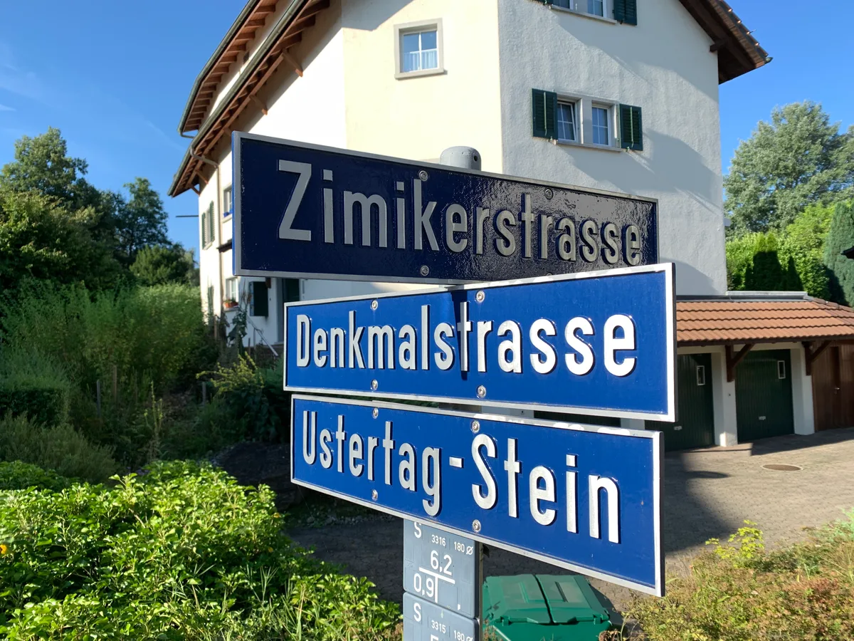 Drei Strassentafeln mit  Zimikerstrasse, Denkmalstrasse und Ustertag-Stein.