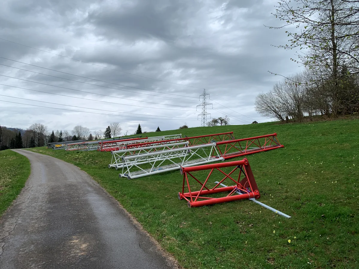 Teile eines Masts liegen an einem Strässchen.