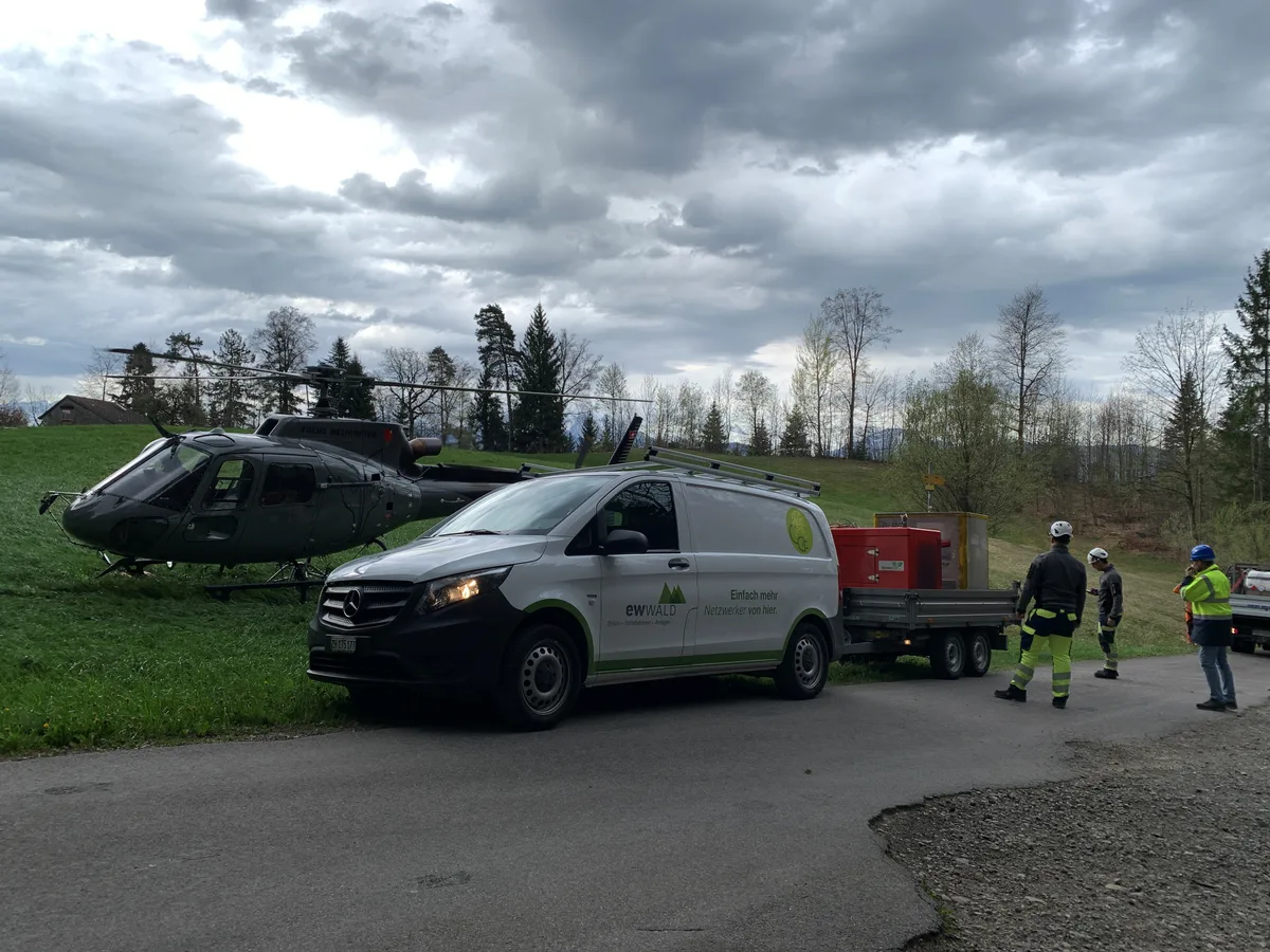 Ein Transporter mit Anhänger und ein Helikopter stehen auf dem Batzberg.