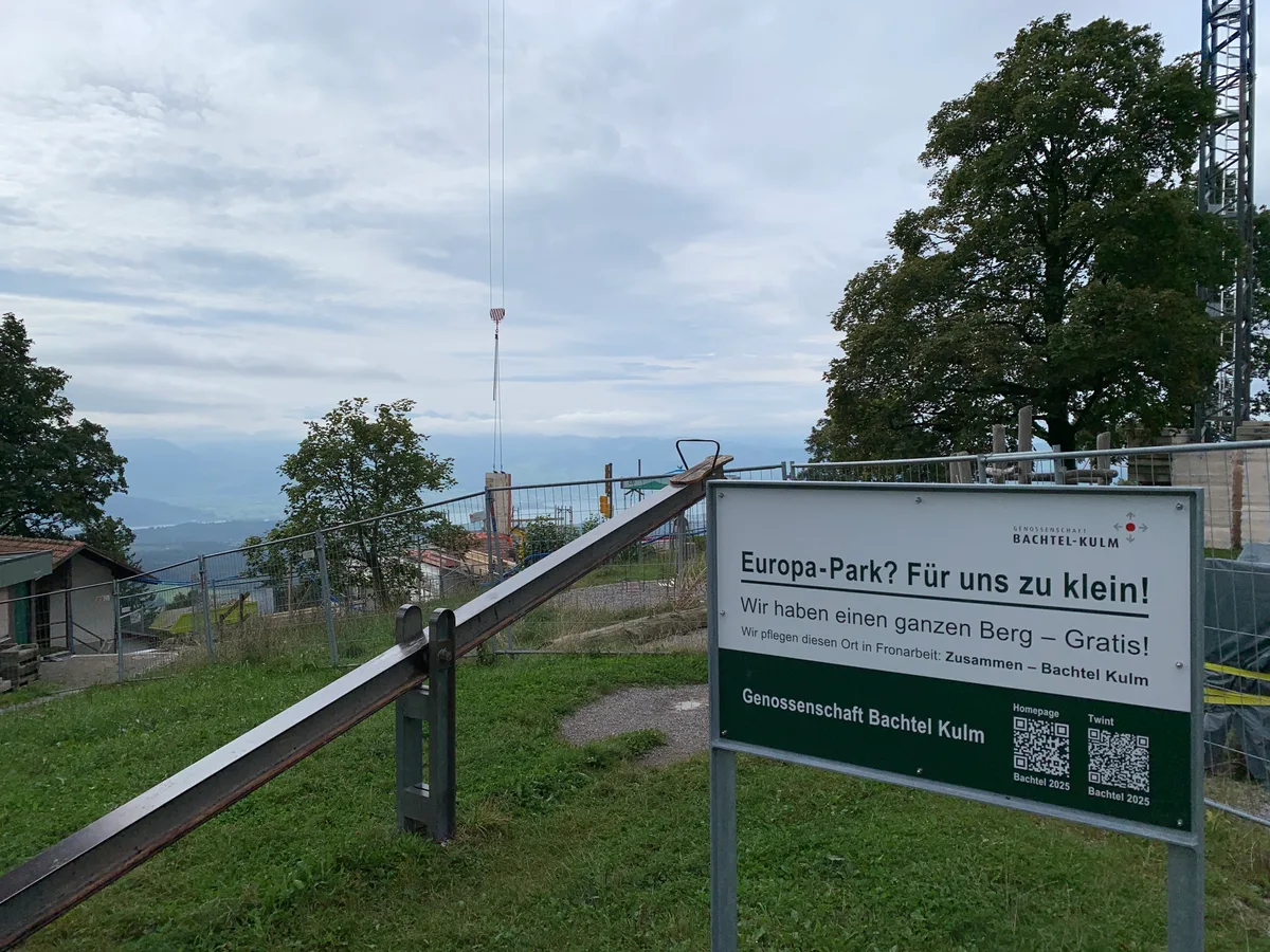 Blick auf eine Werbetafel, den Spielplatz und die Baustelle auf dem Bachtel.
